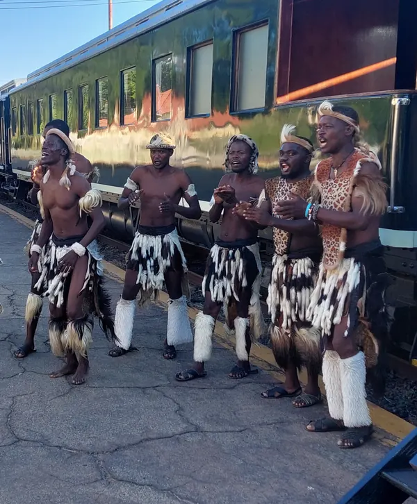 Groupe de danseurs en tenue traditionnelle, instant de chant et de percussions