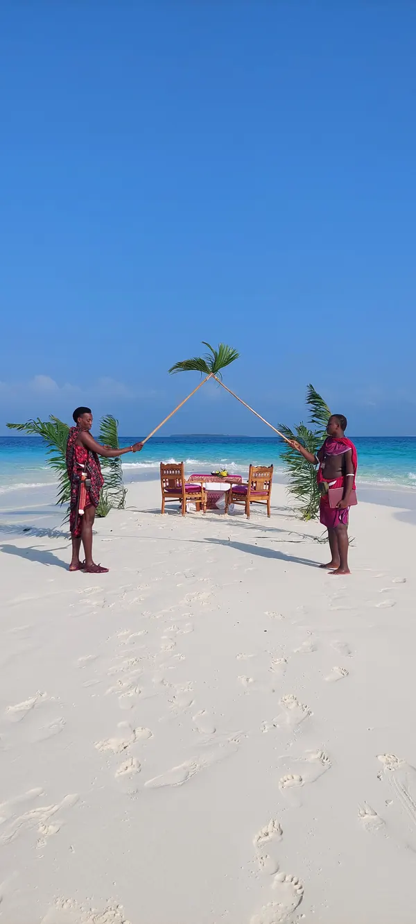 Cérémonie de mariage sur une plage de Zanzibar, table dressée sous un dais de palmes