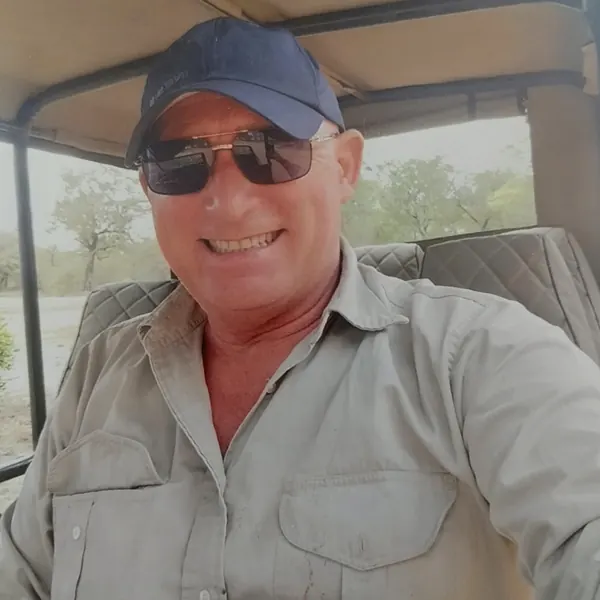 Patrick au volant d'un 4x4 de safari, en brousse